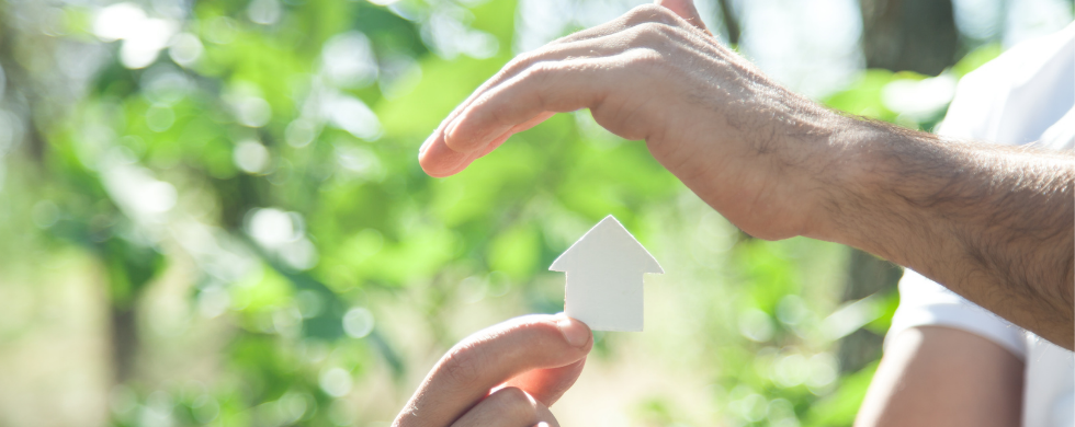 hands holding a cut out of a house